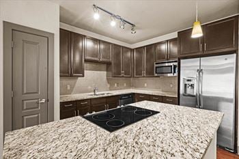 a kitchen with granite countertops and dark wood cabinets